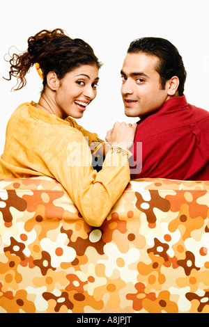 studio portrait of young asian couple, standing back to back, looking ...