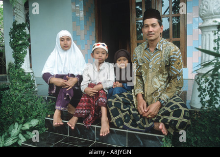 INDONESIA. TRADITIONAL JAVANESE FAMILY OUTSIDE THEIR HOME NEAR MALANG IN EAST JAVA. Stock Photo