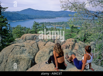 Women sitting on rocks look at Big Bear Lake in Southern California Stock Photo