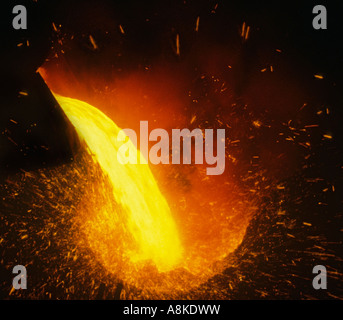 Molten metal steel being poured pouring into a Bessemer converter in a steel works foundry viewed from a close dramatic elevated position Stock Photo