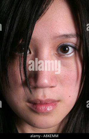 Cloes up of a beautiful asian woman with a serious and friendly expression looking intently at the camera Stock Photo