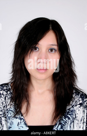 Pretty asian woman looking into the camera with a friendly but serious open expression Stock Photo