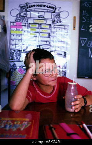 Child drinking a bottle of milk during a mid-morning break at school in Solingen, North Rhine-Westphalia, Germany. Stock Photo