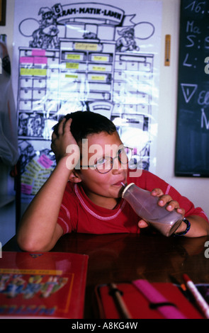 Child drinking a bottle of milk during a mid-morning break at school in Solingen, North Rhine-Westphalia, Germany. Stock Photo