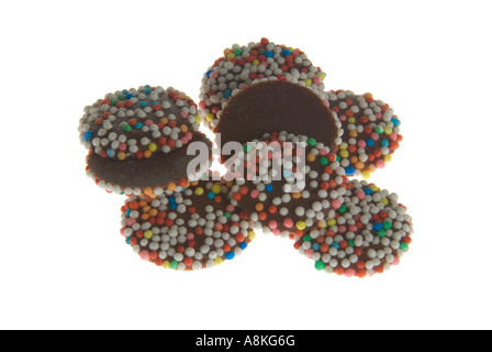 Horizontal close up of a pile of milk chocolate buttons on a white background.