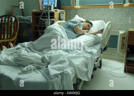 Hispanic-American woman in early stages of labor waits in delivery room Stock Photo