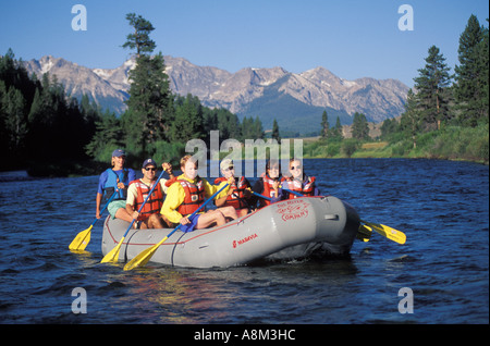 USA IDAHO Happy rafters paddling on the Upper Salmon River with Sawtooth Mountains in the background near Stanley Stock Photo