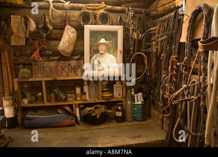 IDAHO INDIAN CREEK GUEST RANCH Cowboy looking in mirror inside horse tack shack MR Stock Photo