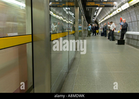 Horizontal wide angle interior of people waiting on the platform for the Tube at Westminster underground station. Stock Photo