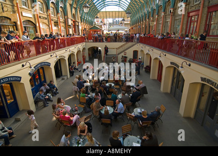 Horizontal close up of people being entertained by street performers inside the 'Apple Market' at Covent Garden. Stock Photo