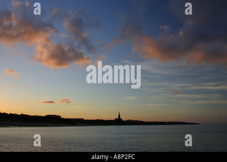 ENGLAND Tyne Wear Tynemouth The setting sun illuminates clouds behind long sands Cullercoats Stock Photo