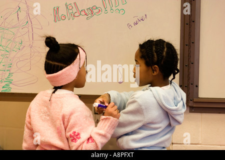 Two 5 year old girls at the blackboard. St Paul Minnesota USA Stock Photo