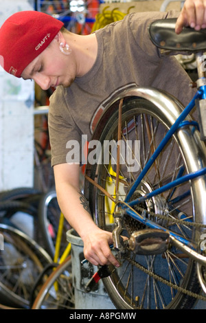 Worker making a repair on a bicycle. Youth Express Bike Shop St Paul Minnesota USA Stock Photo