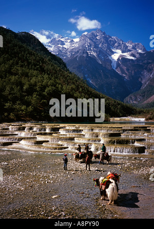 China Yunnan Lijiang Jade Dragon Snow Mountain Waterfall with tourist on Yaks Stock Photo