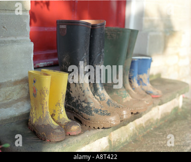 Healthy family concepts of colorful wellington boots on the home doorstep in the countryside with blue door red yellow boots Stock Photo