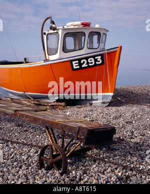 Orange boat on pebble beach Stock Photo - Alamy