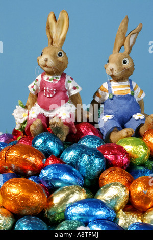 two Easter bunnies sitting on Easter eggs Stock Photo
