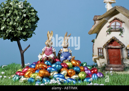 two Easter bunnies sitting on Easter eggs Stock Photo