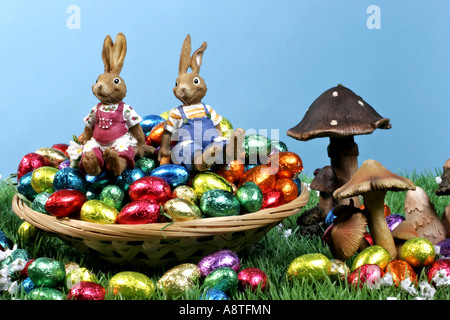 two Easter bunnies sitting on Easter eggs Stock Photo