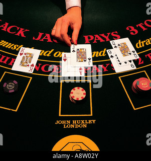 Close-up of female dealer's hand dealing cards on Blackjack table. Stock Photo