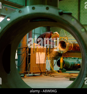 Industry. Manufacturing. Man welding steel pipe section. Stock Photo