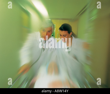 Hospital Accident and Emergency Unit Casualty.  Two doctors pushing patient on trolley gurney. Speed impression. Stock Photo