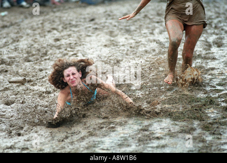 Humor fall Woodstock music festival 1994 Woman falling in mud sliding down muddy hill Stock Photo