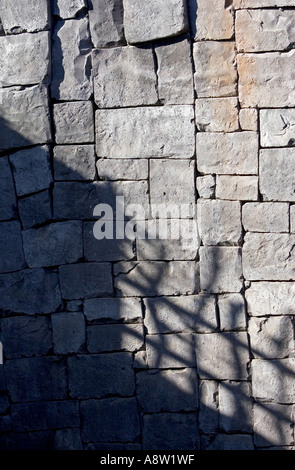 Deep sunny shadows on a large tiled stone wall Stock Photo
