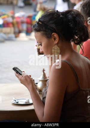 Girl at Cafe in Marrakech using Mobile Phone Morocco Stock Photo