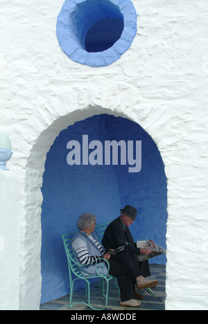 Old Couple Relaxing in Shelter on Waterfront at Portmeirion Village Wales United Kingdom UK Stock Photo