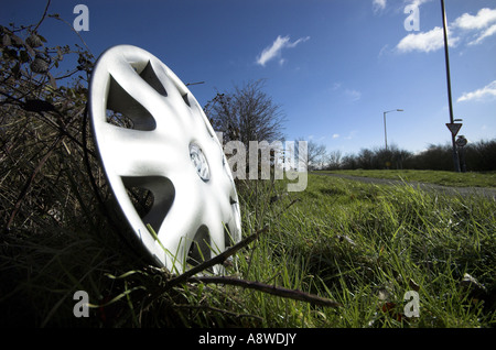 Silver car wheel hub cap on the side of the road close up Stock Photo