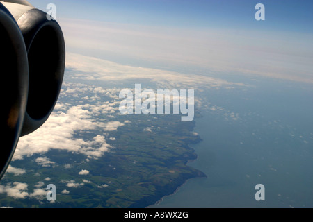 View out of Aircraft Window clouds and sea and coast of England Stock Photo