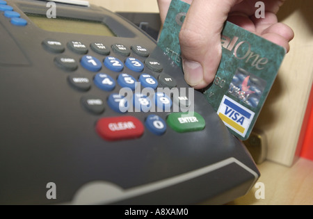Credit card being swiped through a machine by a man UK Stock Photo