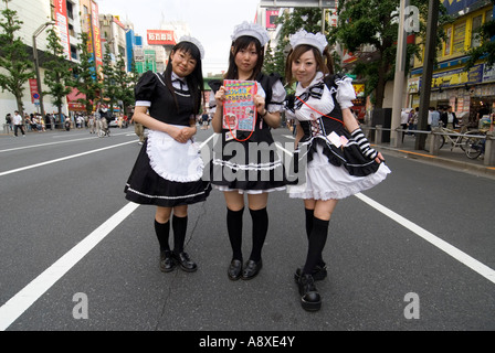 Young girls in maids costumes on street advertising Maids cafe in Akihabara Tokyo Japan Stock Photo