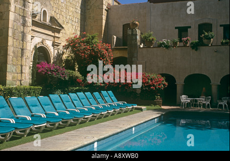 A former monastery, the Camino Real hotel in Oaxaca Mexico, its handsome blue pool and pool loungers Stock Photo
