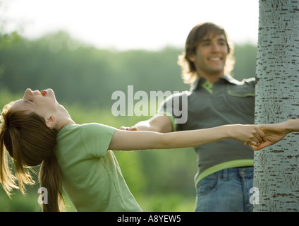 Young people making circle around tree Stock Photo