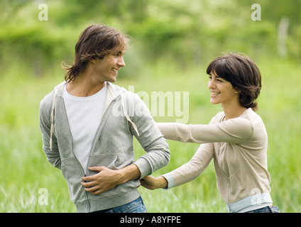Young couple outdoors, man looking at woman over shoulder Stock Photo