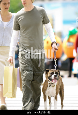 Young couple with dog crossing street Stock Photo