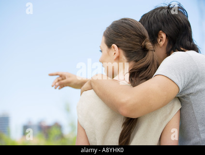 Young couple in urban setting, man pointing Stock Photo