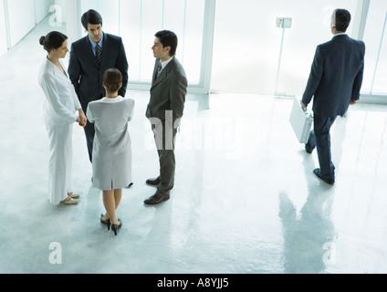 Group of business people standing in lobby, talking Stock Photo