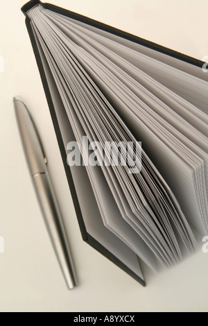 Looking down on a part open notebook standing upright and a pen Stock Photo