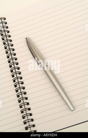 A pen lying on a page of an open notebook Stock Photo