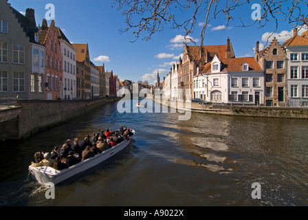 Horizontal wide angle of guided boat tour taking in the views of the traditional gabled buildings along the canal on a sunny day Stock Photo