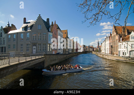 Horizontal wide angle of guided boat tour taking in the views of the traditional gabled buildings along the canal on a sunny day Stock Photo