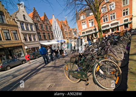 Horizontal wide angle of a typical streetscene in central Bruges, a row of parked bicycles on Steenstraat on a sunny day. Stock Photo