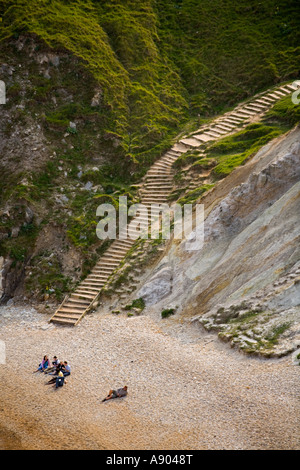 visitors relax on the beach at Man O War Bay behind Durdle Door Dorset UK Stock Photo