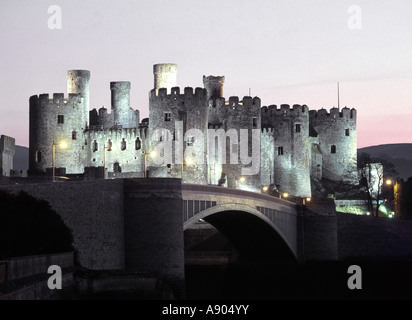 Historical Conwy castle dusk floodlighting illuminating stone walls modern road bridge over River Conwy Snowdonia national park Gwynedd North Wales Stock Photo