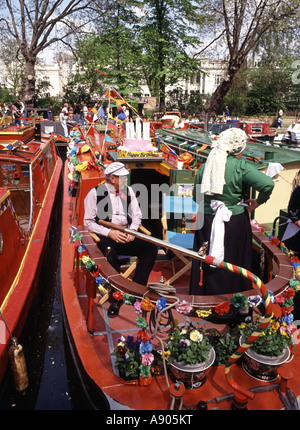 Colourful sunny Little Venice canal festival moored narrowboat & close up of crew dressed in traditional costumes Paddington Basin London England UK Stock Photo