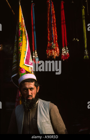 Pakistan NWFP Peshawar Qissa Khawani Bazaar man below decorative hair tassels and headscarves dupatta Stock Photo
