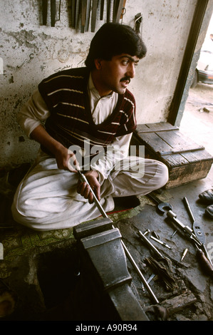 Pakistan NWFP Darra Adam Khel man making rifle barrel Stock Photo